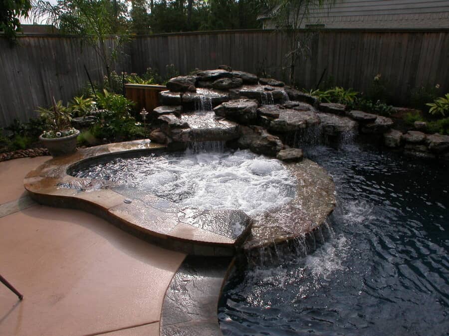 Large trendy backyard stone and custom-shaped natural hot tub photo in Houston