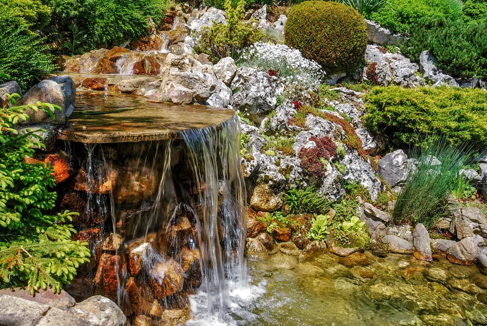 Small artificial waterfall in man made tropical garden