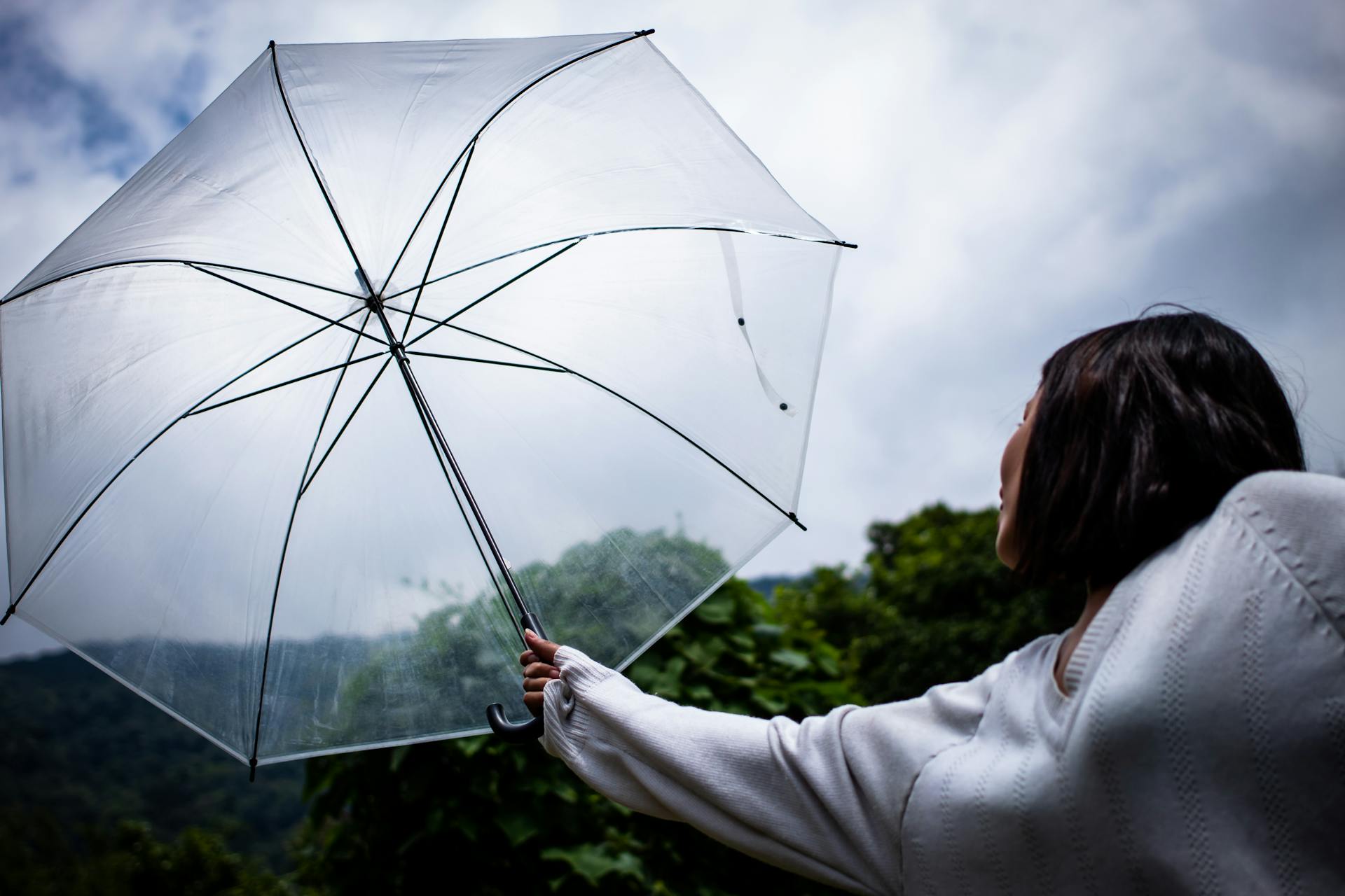 A woman holding a clear plastic umbrella