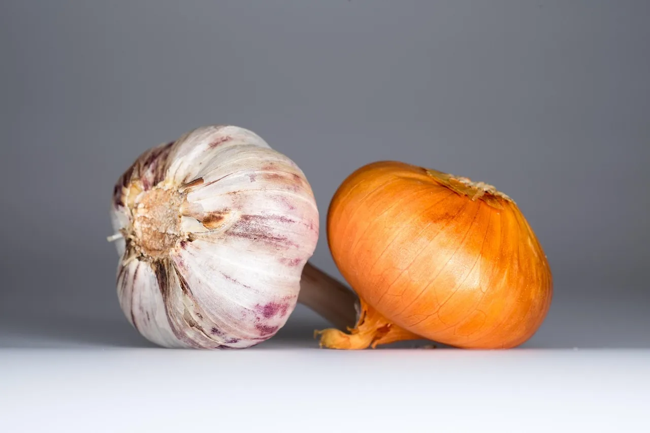 Onion and garlic on a white surface